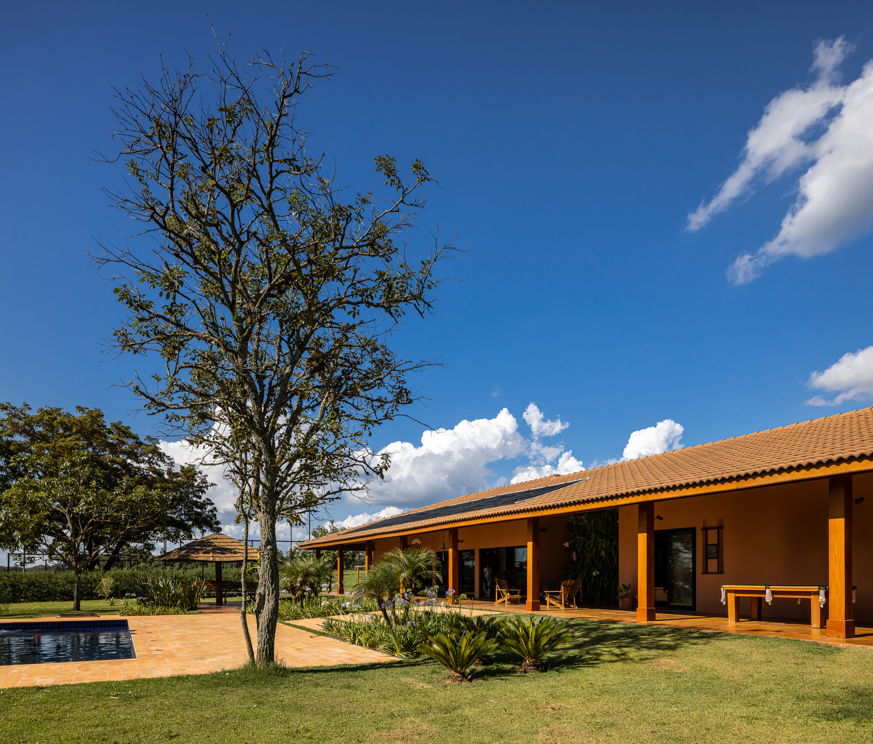 Projeto residencial Arq Besô: casa rural com piscina e paisagismo