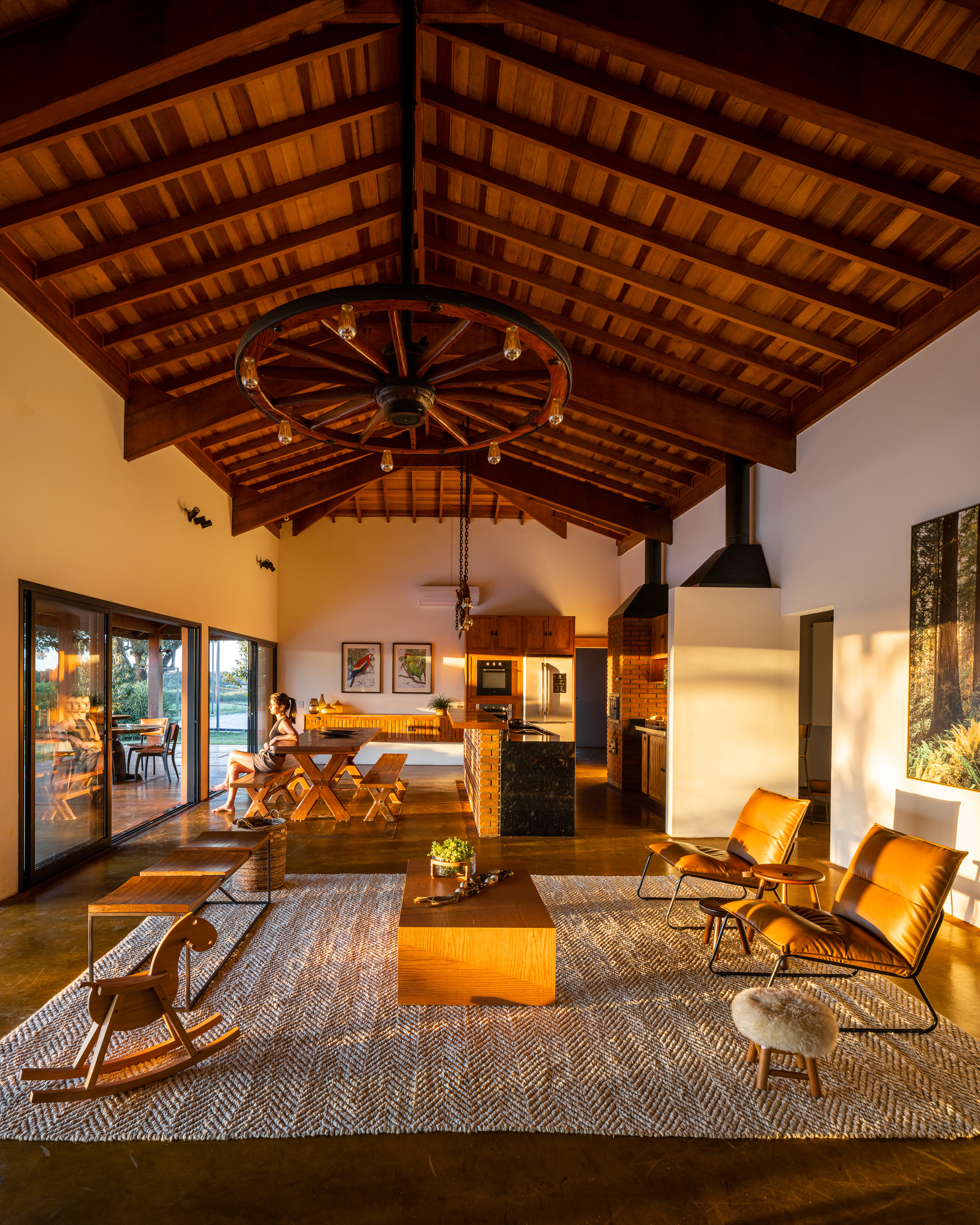 Interior com teto de madeira, poltronas de couro e iluminação natural